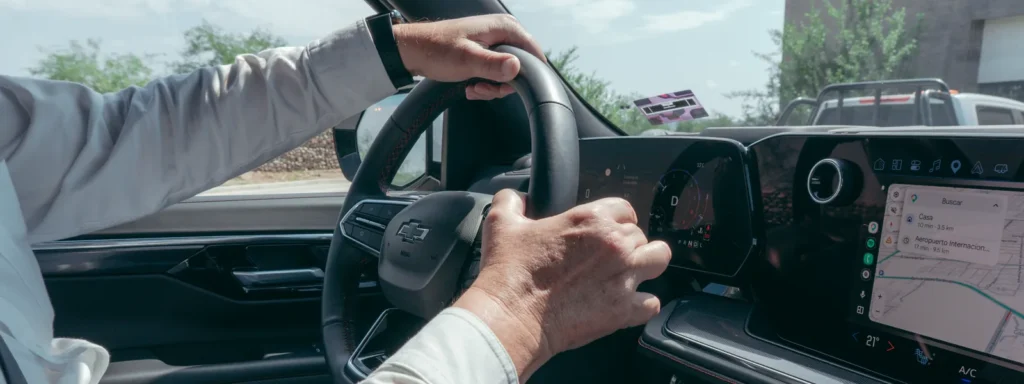Handen aan het stuur van een auto