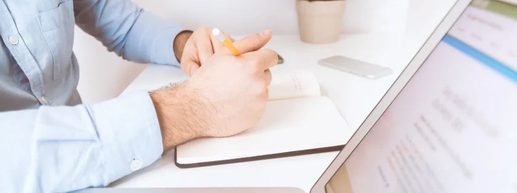 Handen aan een laptop op een werktafel